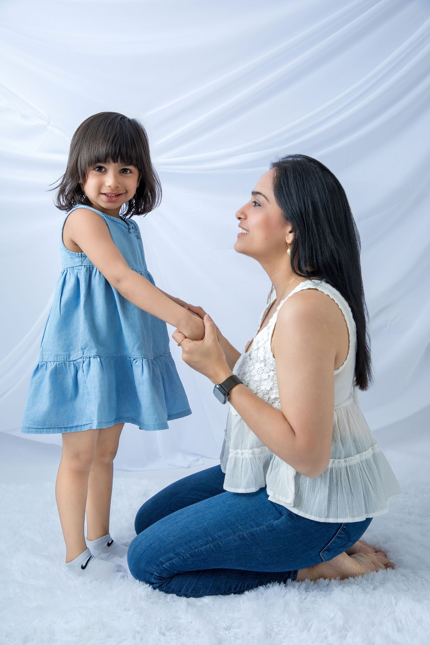 Mother and child sharing tender moments in a white studio setting.