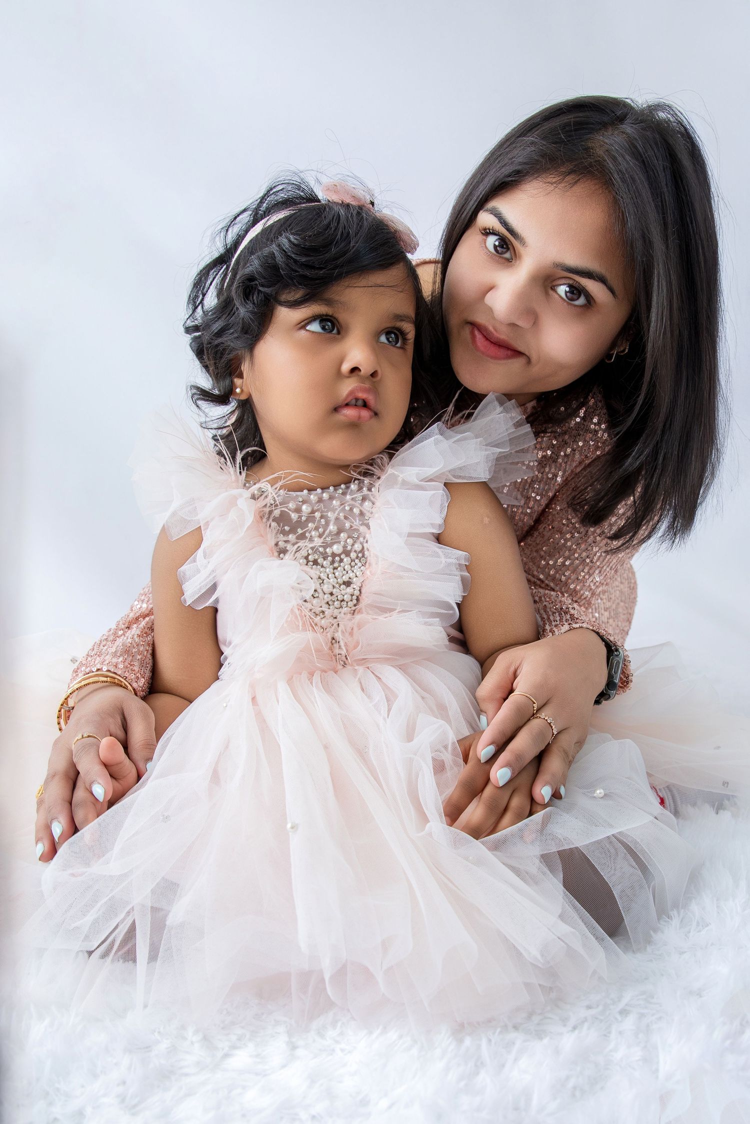 Studio portrait with sparkly dresses and delicate tulle details in soft lighting.