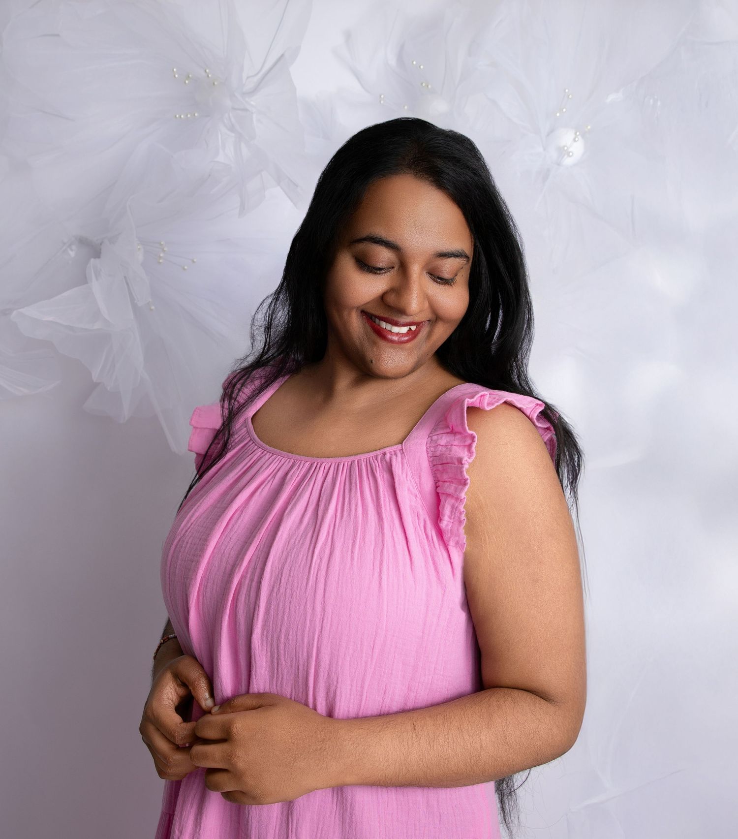 Portrait series in soft pink dress against textured white background.