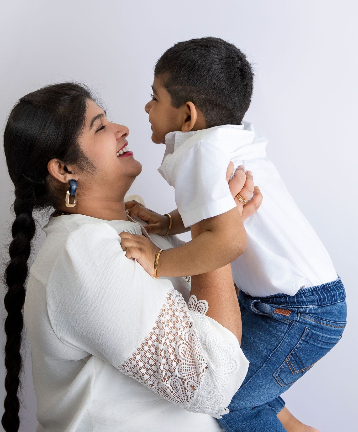 A tender playful moment captured against a white backdrop.