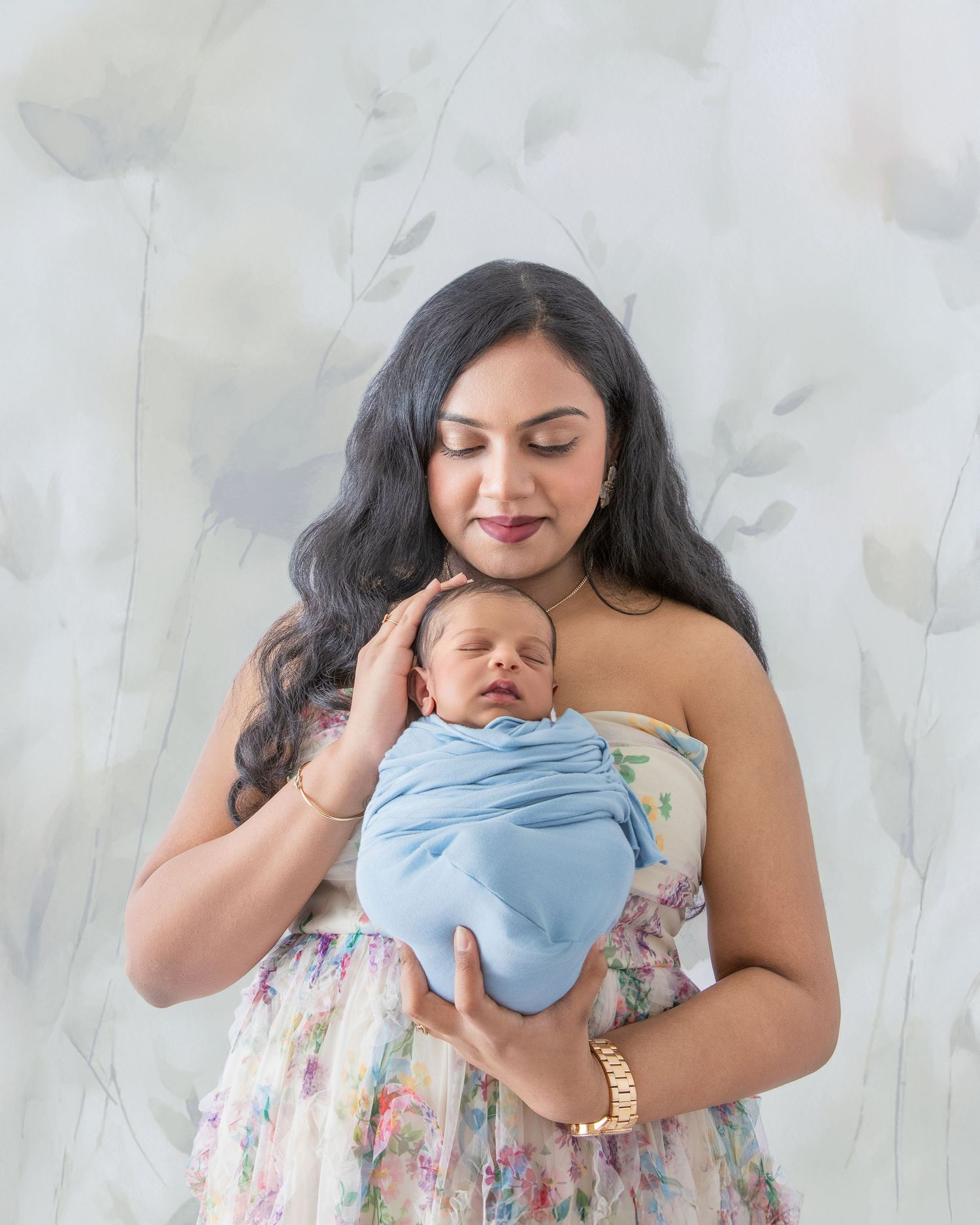 A tender moment captured in a four-part photo series showing a parent and baby sharing loving embraces on a light background.