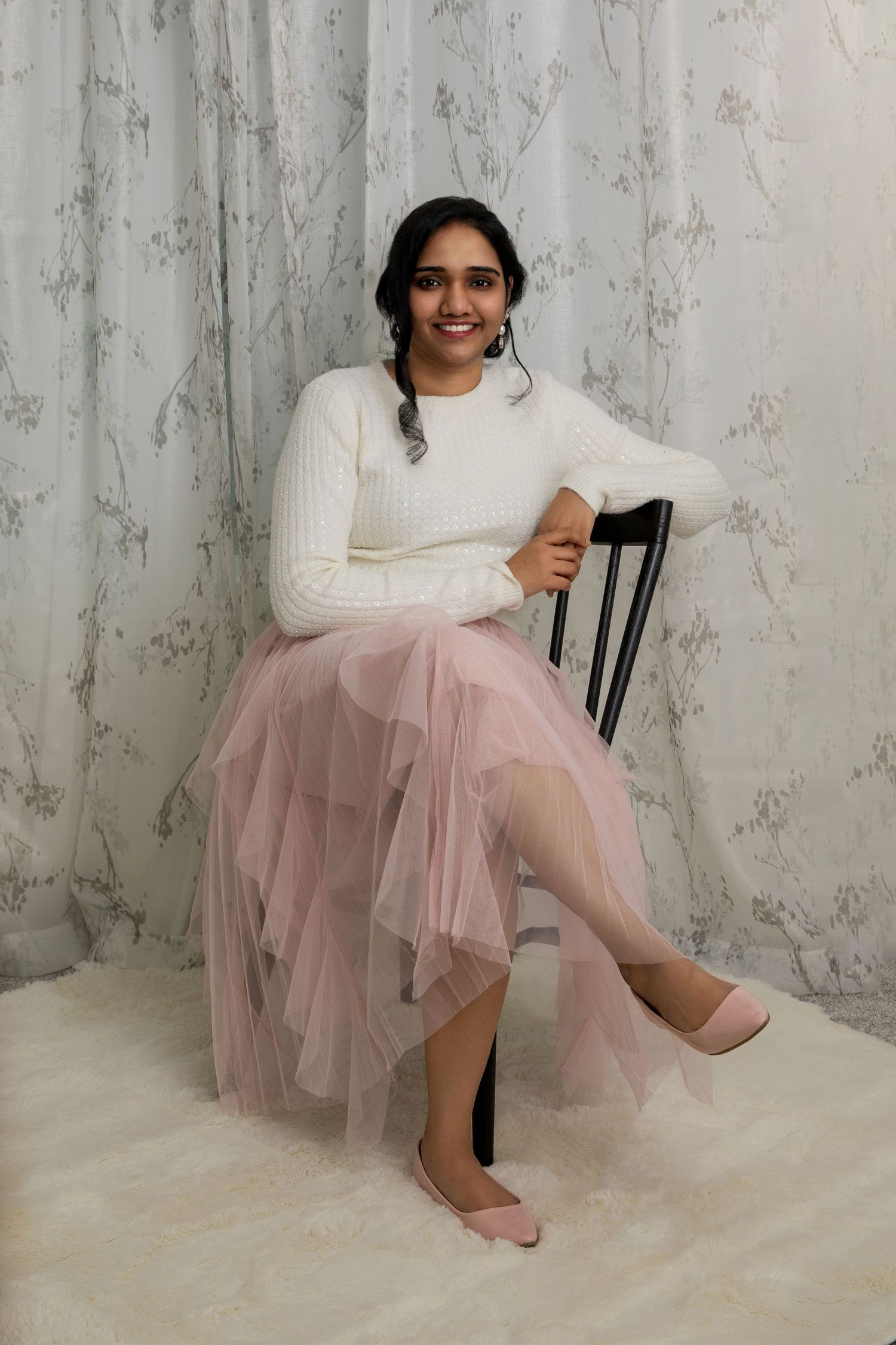 Ethereal portrait session with person in white top and pink tulle skirt against marble backdrop.