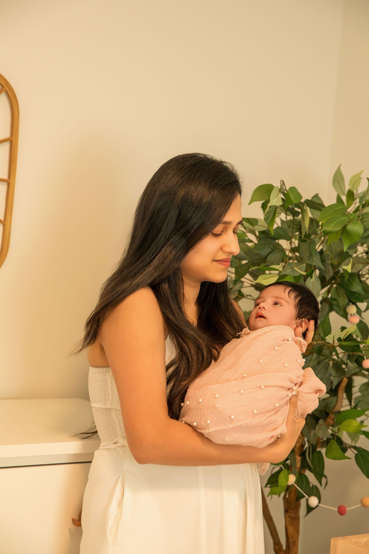 Tender moments between parent and baby captured in white against a warm beige background.
