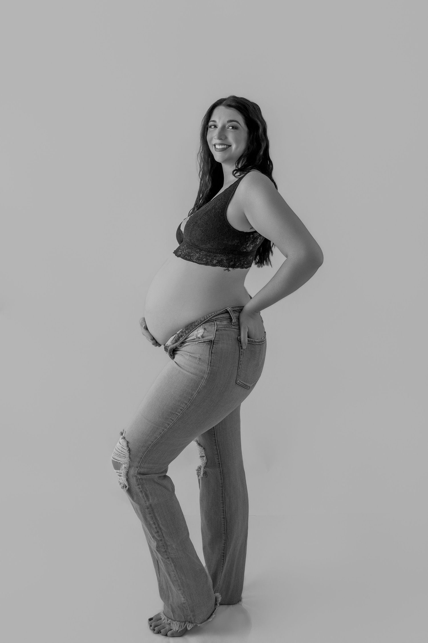 Black and white photo series showing a person in jeans and tank top posing in different standing positions.