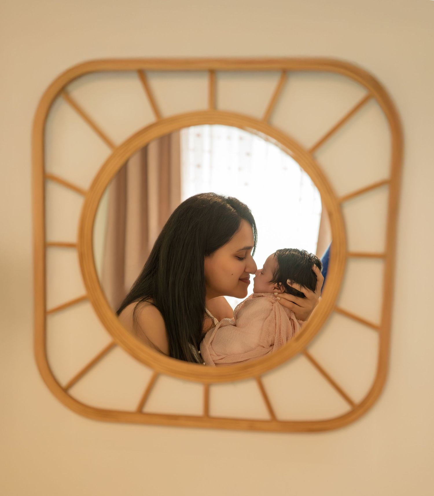 Sweet newborn photography session featuring intimate parent and baby moments through decorative wall frames.