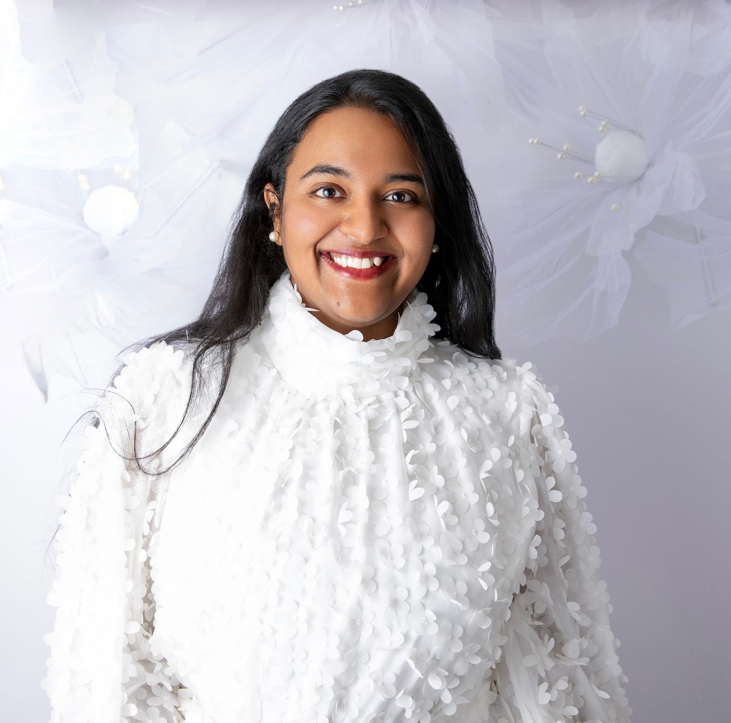 A textured white turtleneck sweater with decorative details creates a striking winter fashion look.