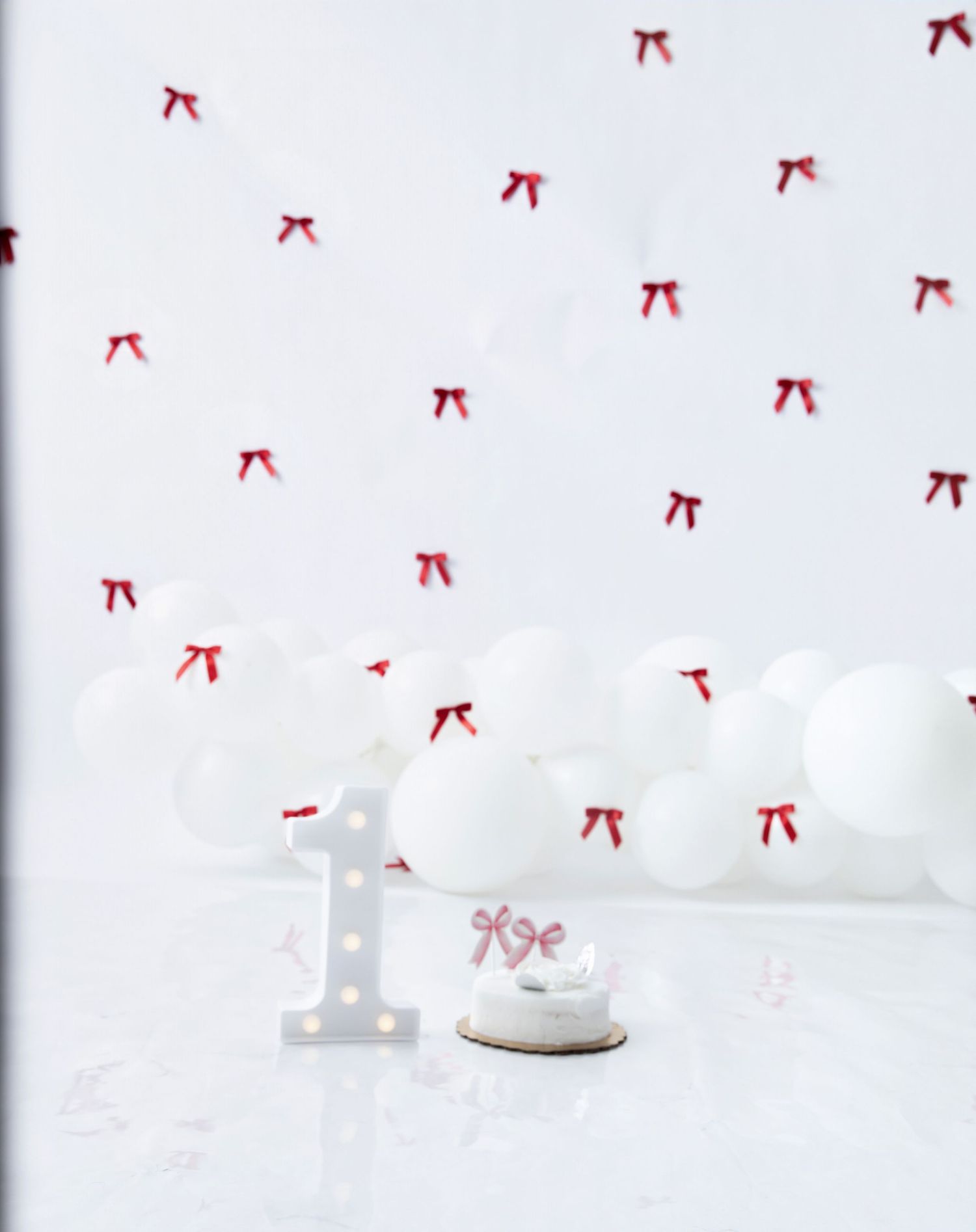 White studio setup with illuminated number one and red bow decorations.