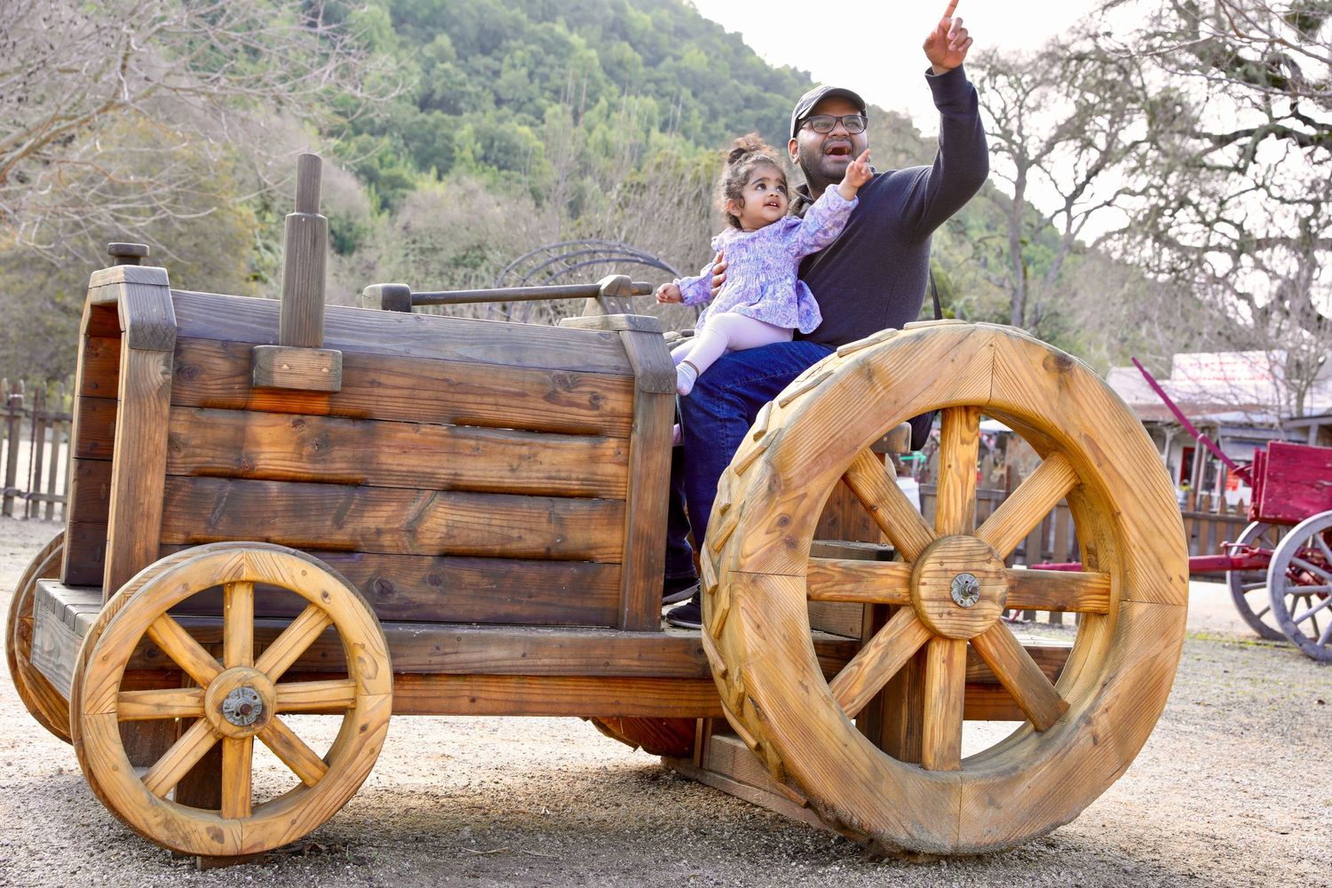 Wooden balance bikes arranged in a row outdoors at a playground.