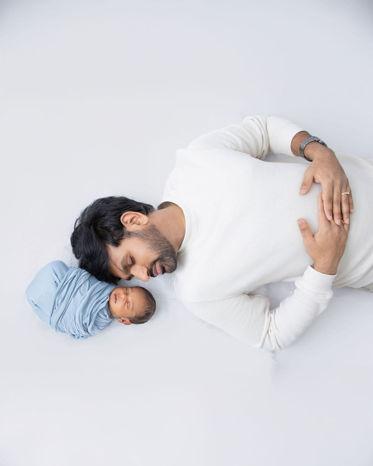 Series of minimalist newborn portraits with baby sleeping on white backdrop in gentle poses.