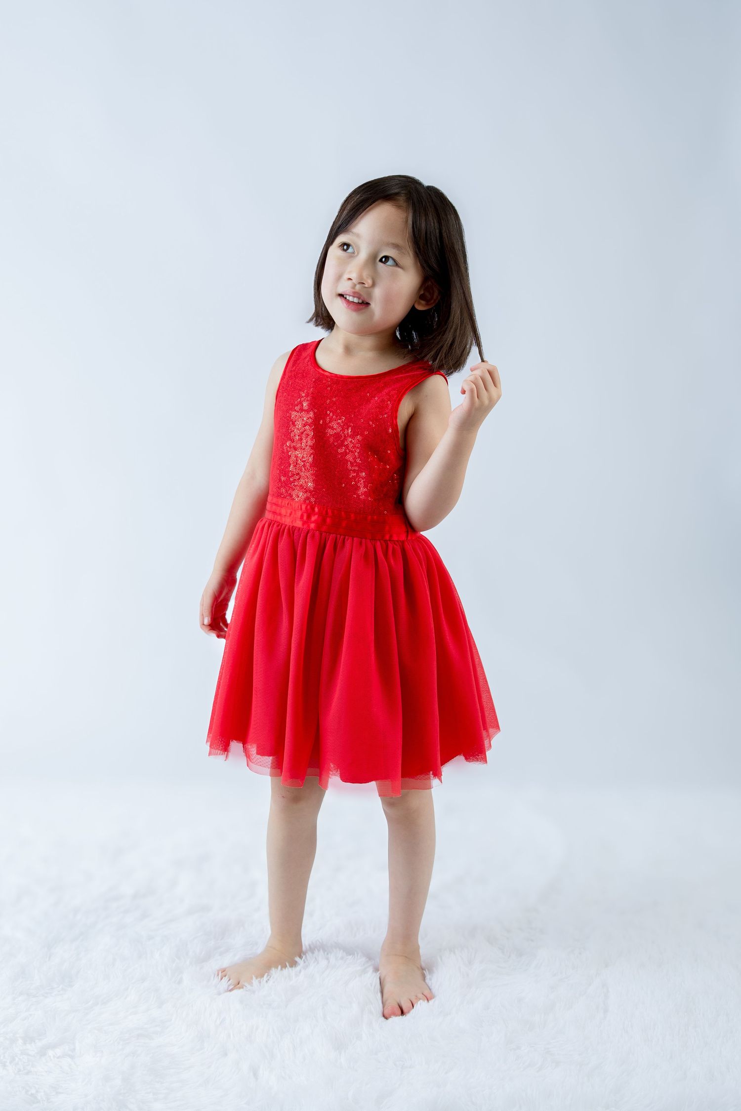 Studio portrait series showing dynamic movement in a red sparkly dress.