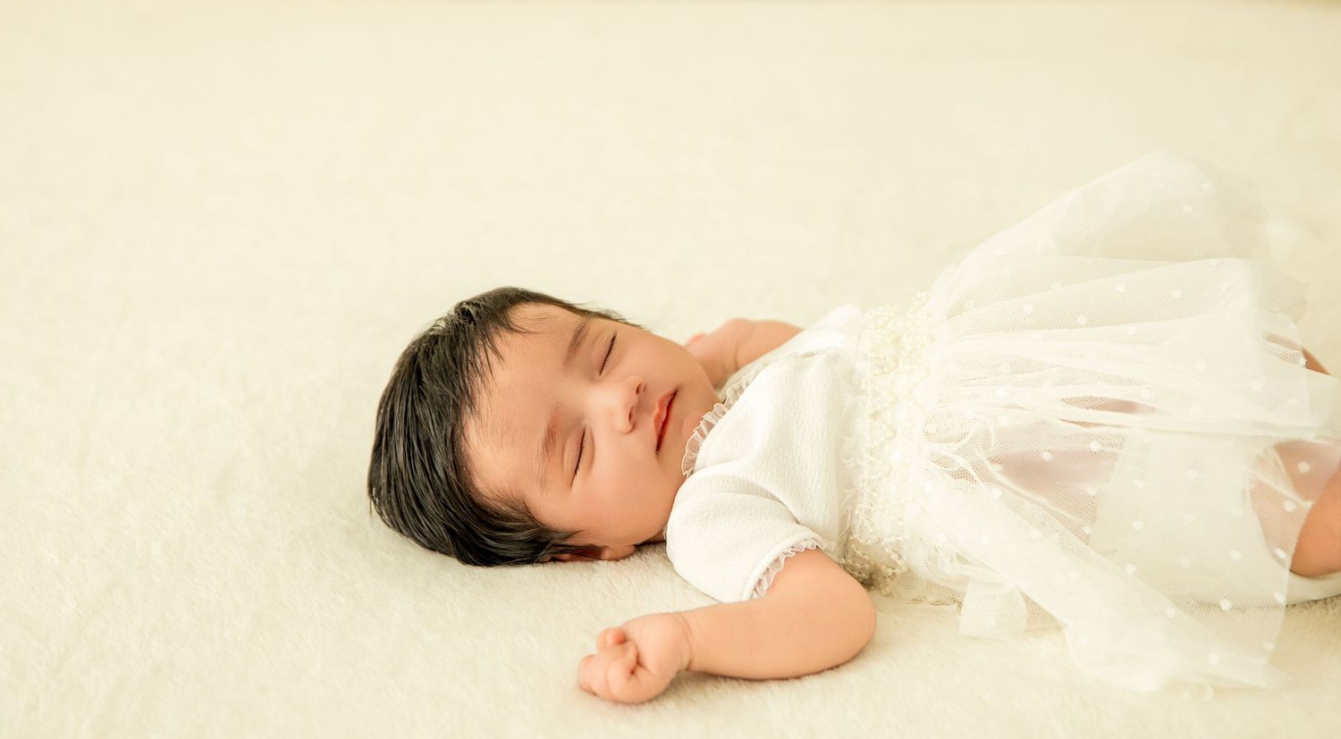 A series of black and white photos showing a sleeping baby in different positions on a white background.