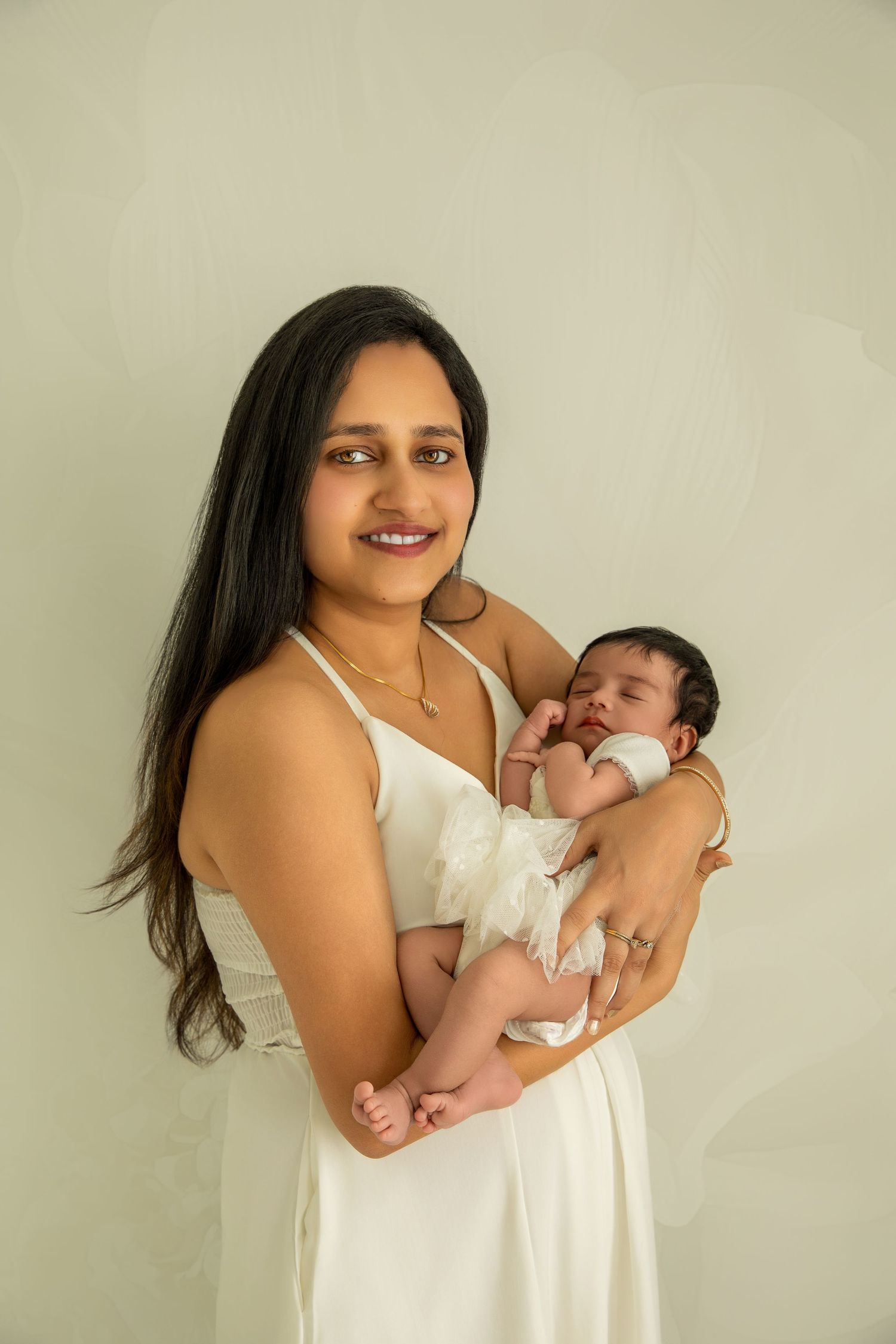 A sequence of tender moments between a parent and newborn baby in white against a neutral background.