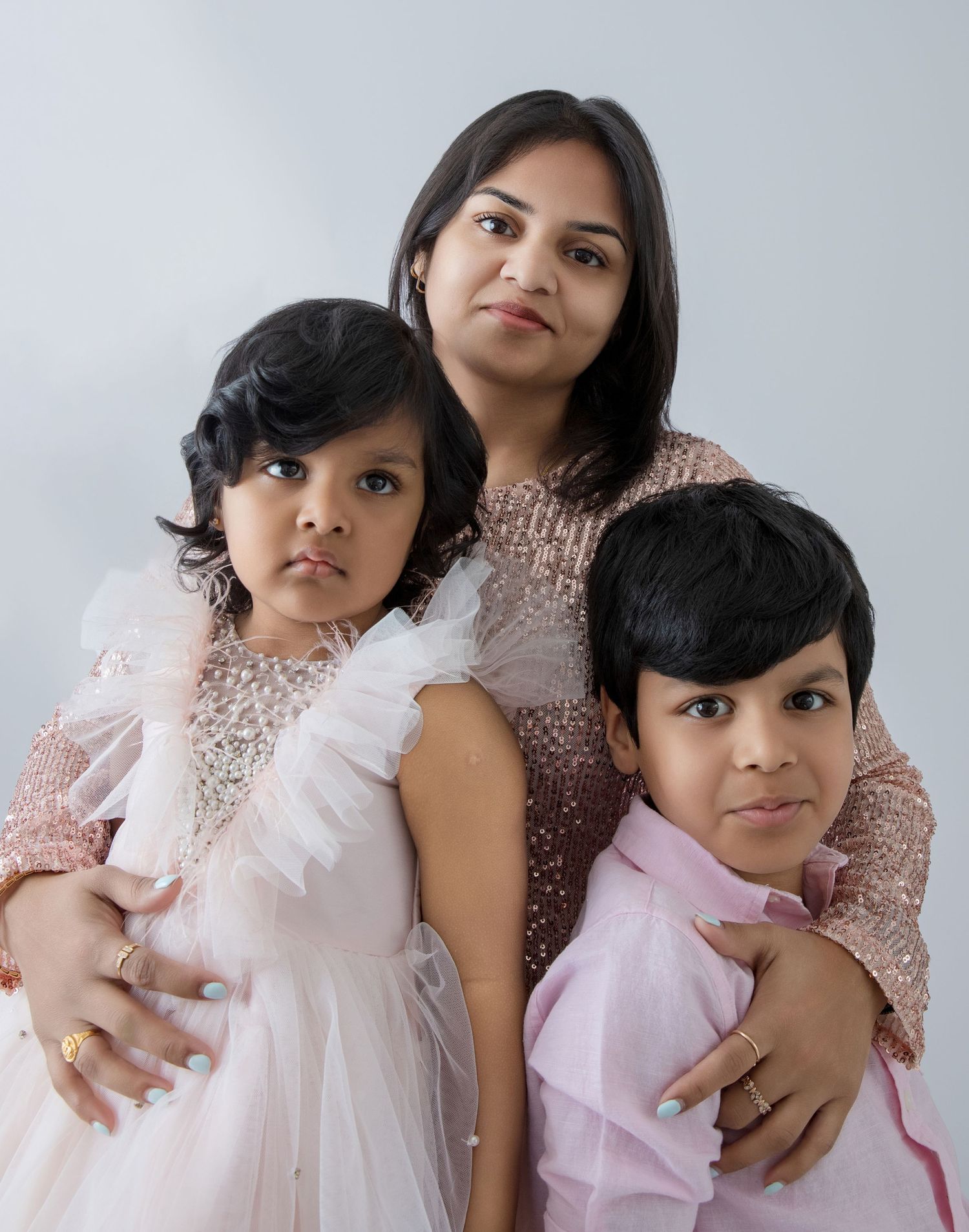 Intimate family portrait series with sparkly blush tops and coordinated styling.