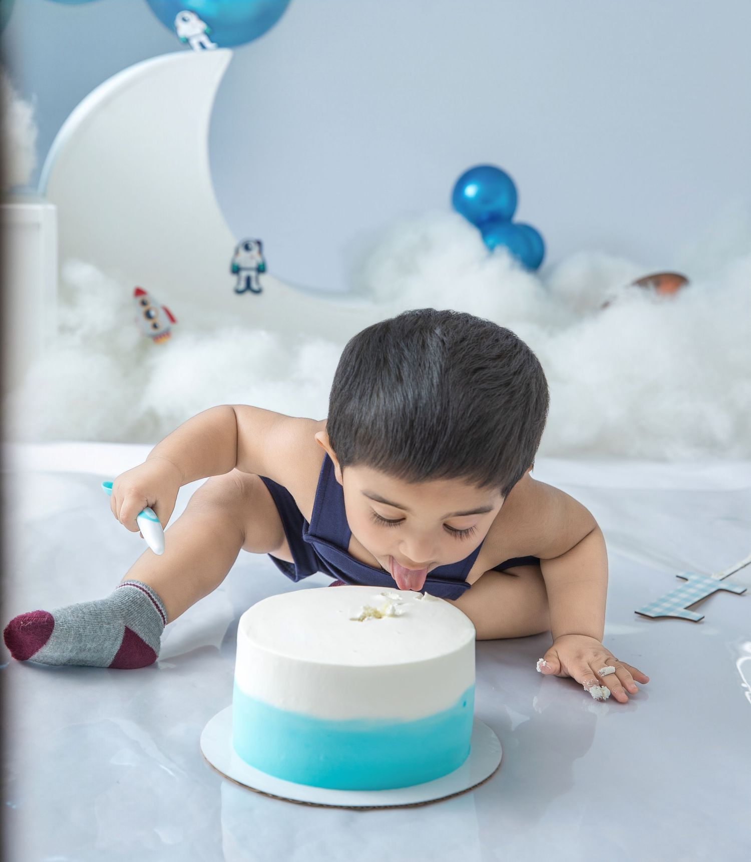 A cake smash photography sequence showing interaction with a blue and white cake on a light background.