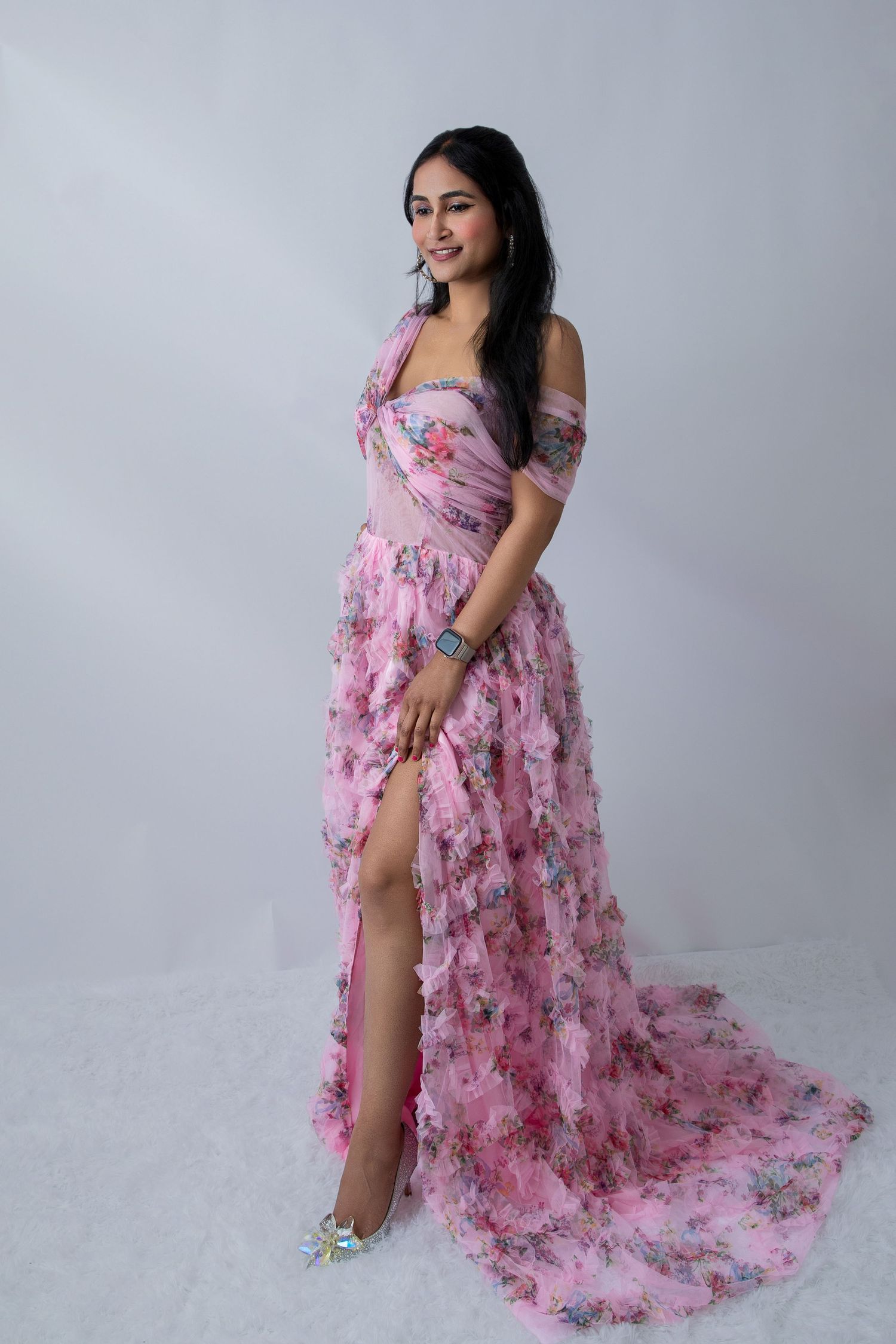 Romantic pink floral maxi dress features a dramatic side slit and flowing fabric in studio lighting.