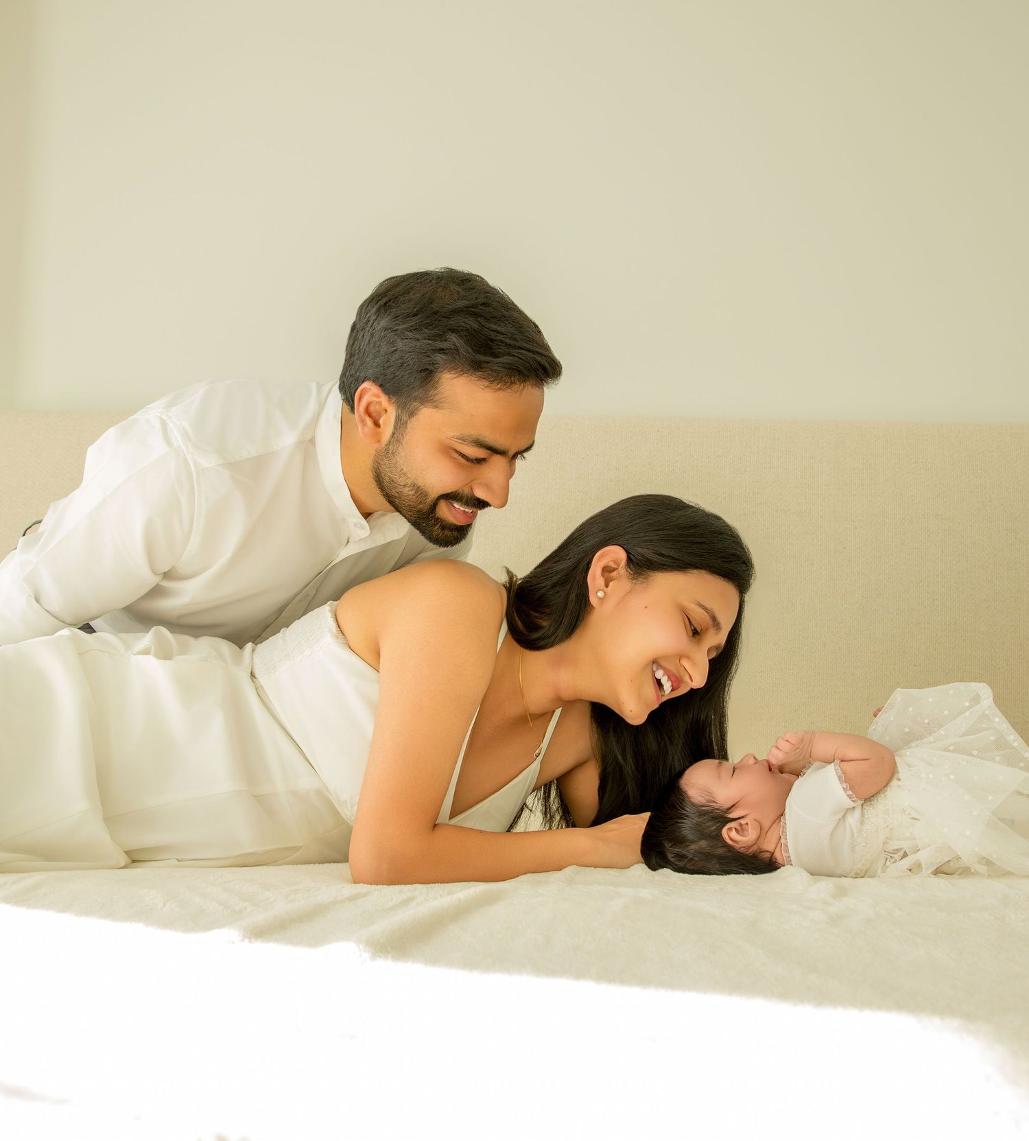 A couple sharing an intimate moment while relaxing together on white bedding.