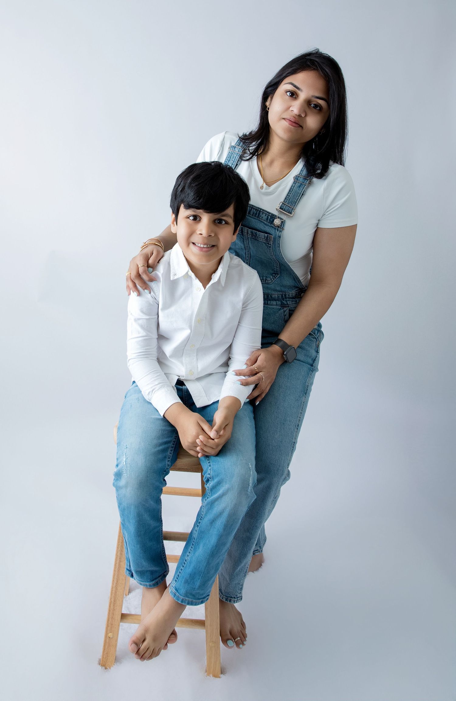 Modern family studio portrait with coordinated denim and white casual wear.