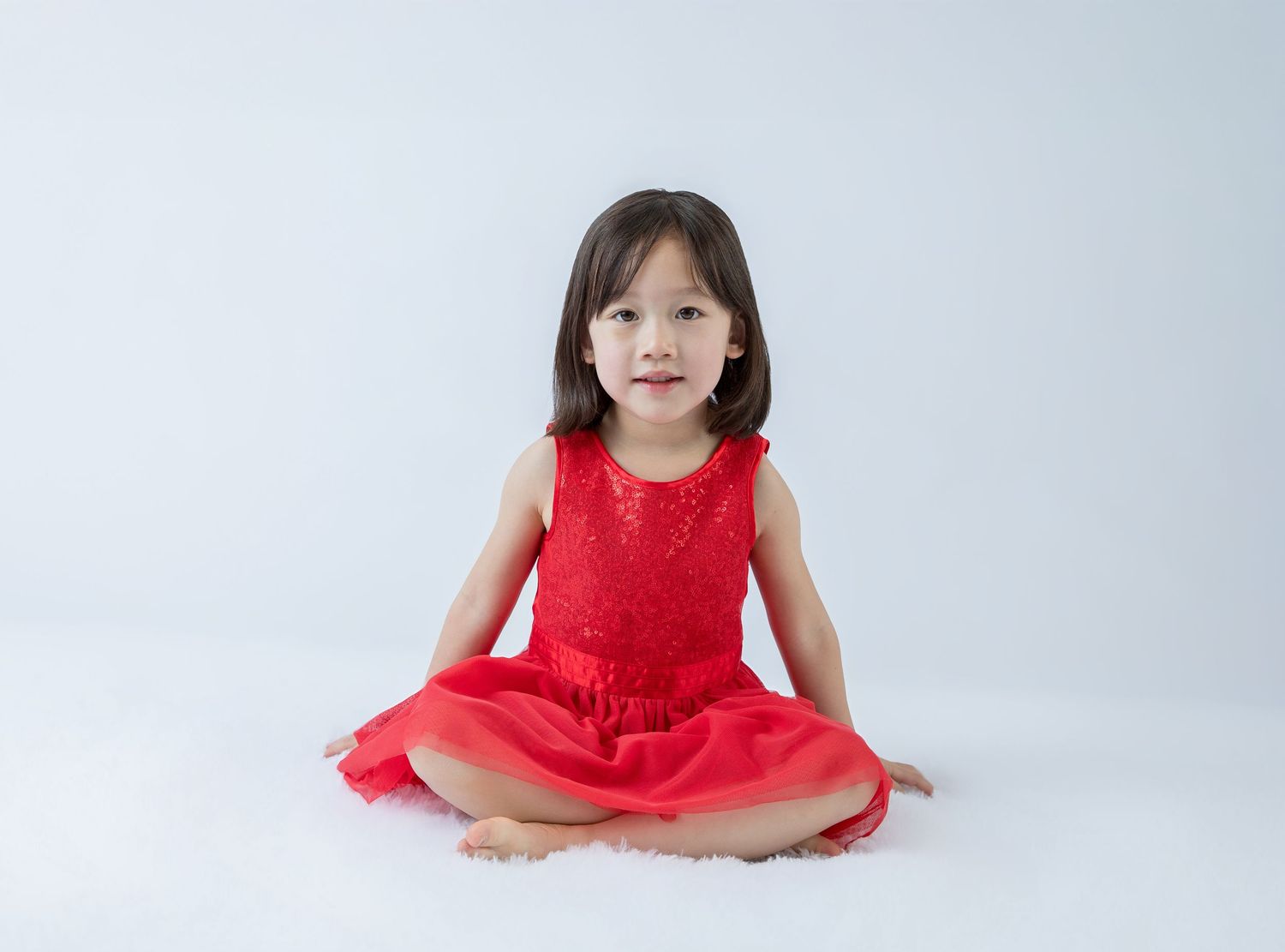 Studio portraits showcasing elegant red dress against minimalist background.