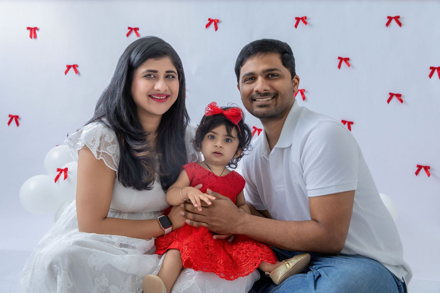 Family photo session with white and red theme decor.