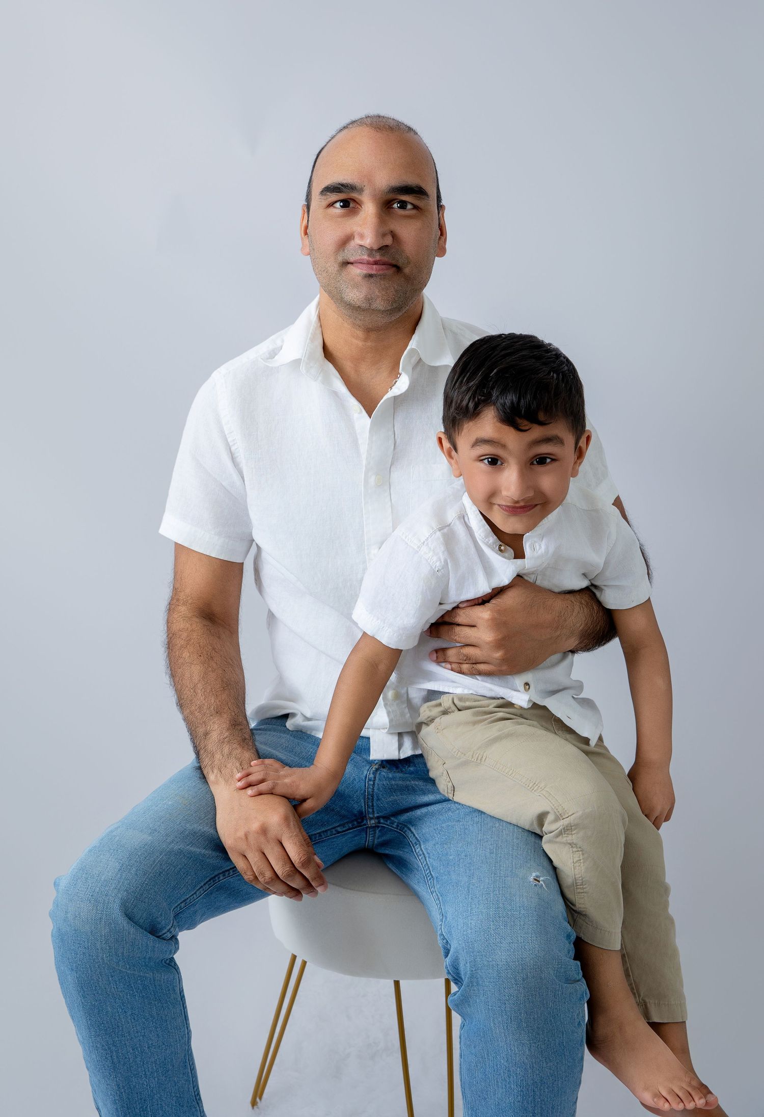Candid father and son moments captured in a bright studio setting.