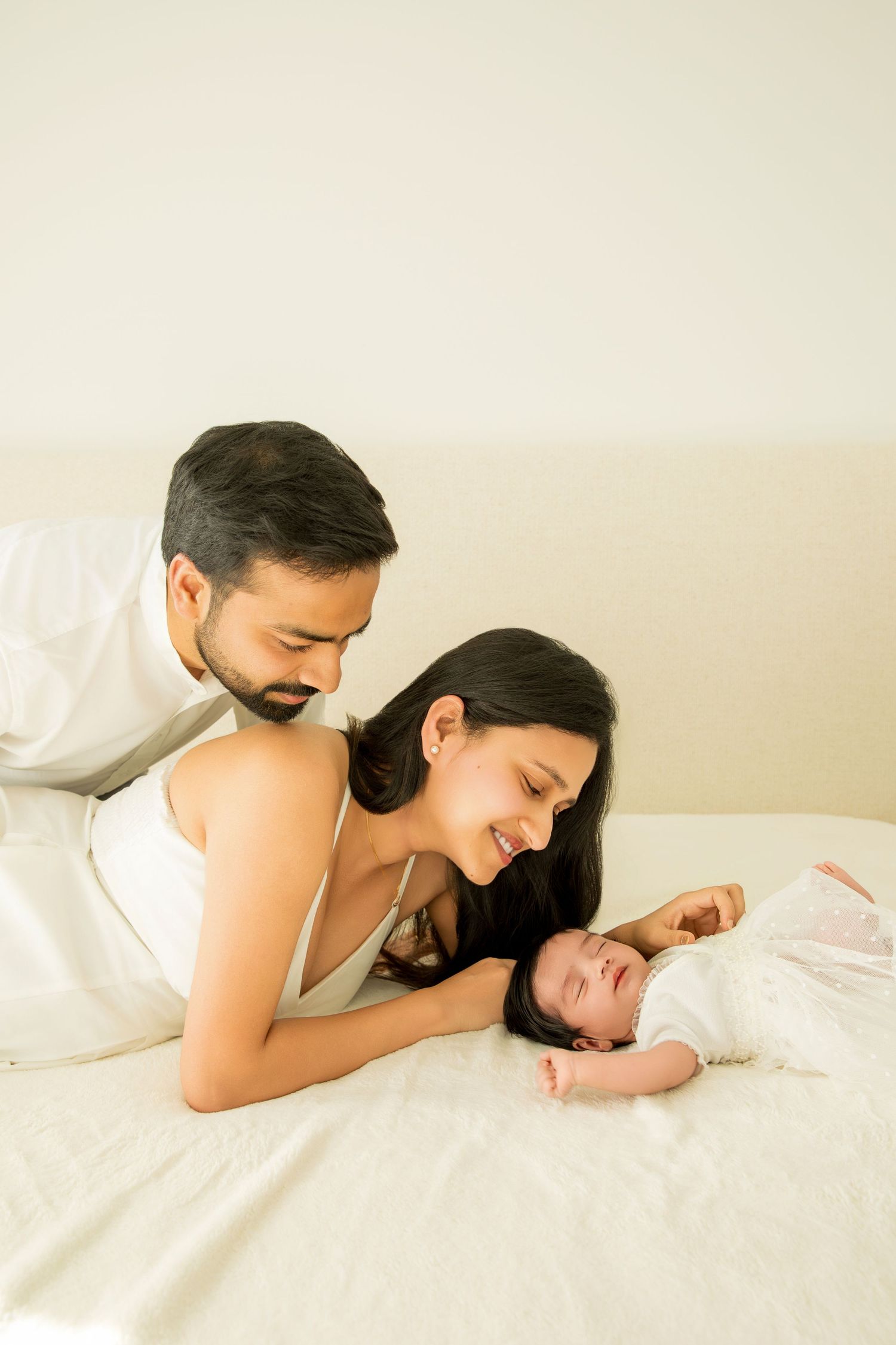 A tender moment captured in a series of photos showing parents lovingly watching their sleeping baby in bed.