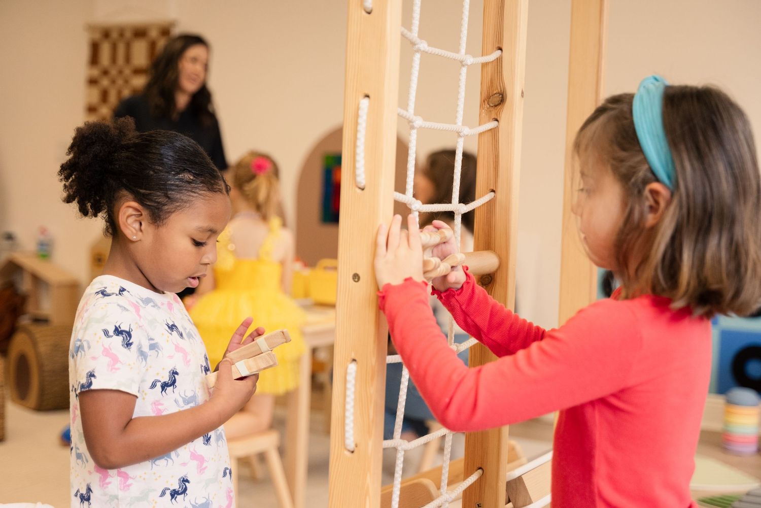 Children engaged in activities at wooden play stations.