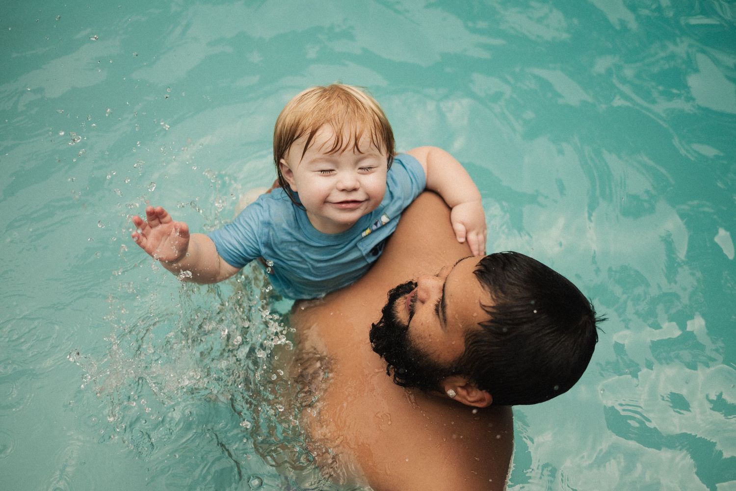 Swimming pool scene with turquoise water and splashing motion.