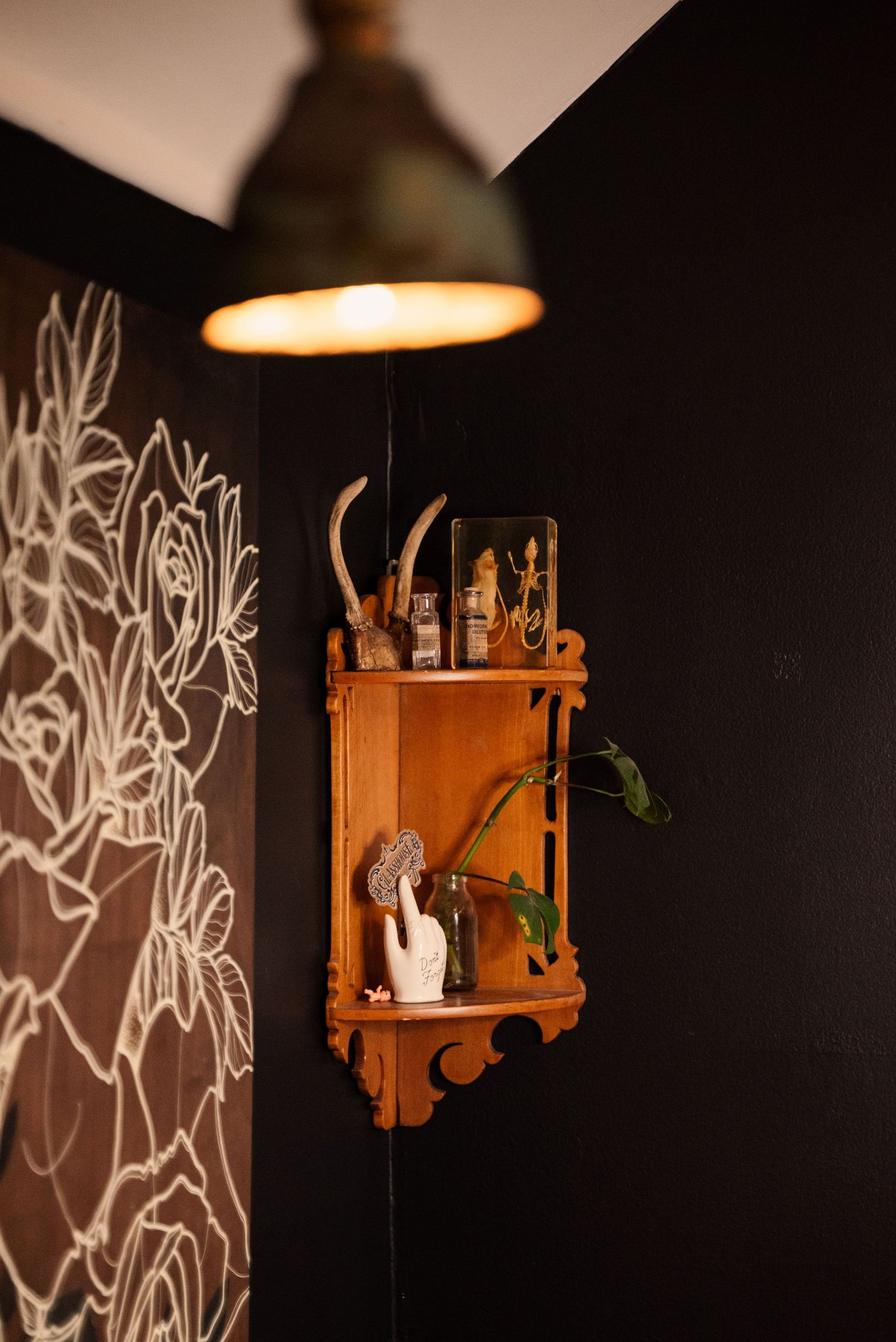 Decorative wooden shelves mounted on black walls with artistic lighting and graffiti designs.