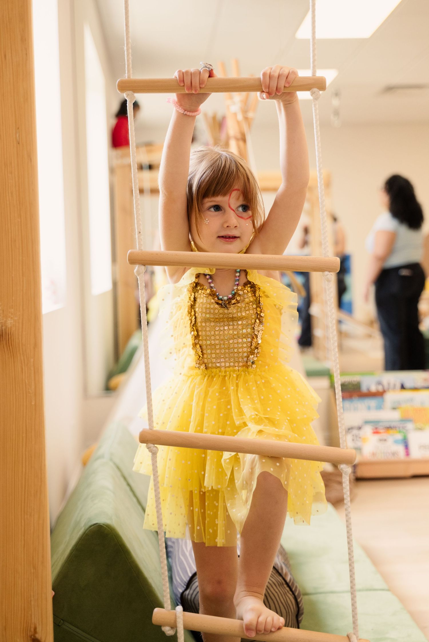 Indoor play area with wooden climbing bars and exercise equipment.