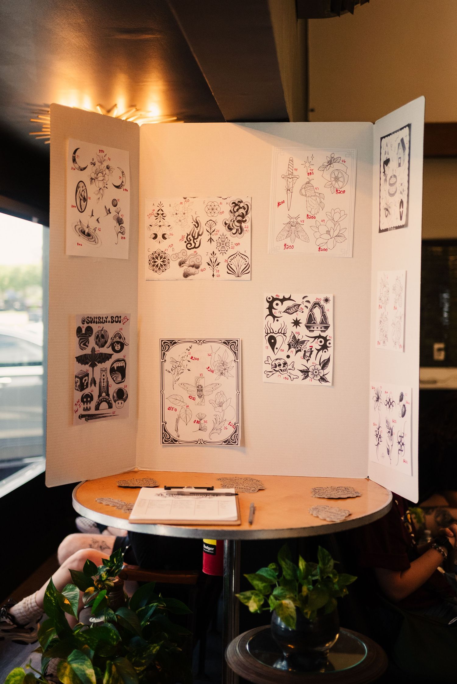 Series of sketch drawings displayed on white panels in an art gallery setting.
