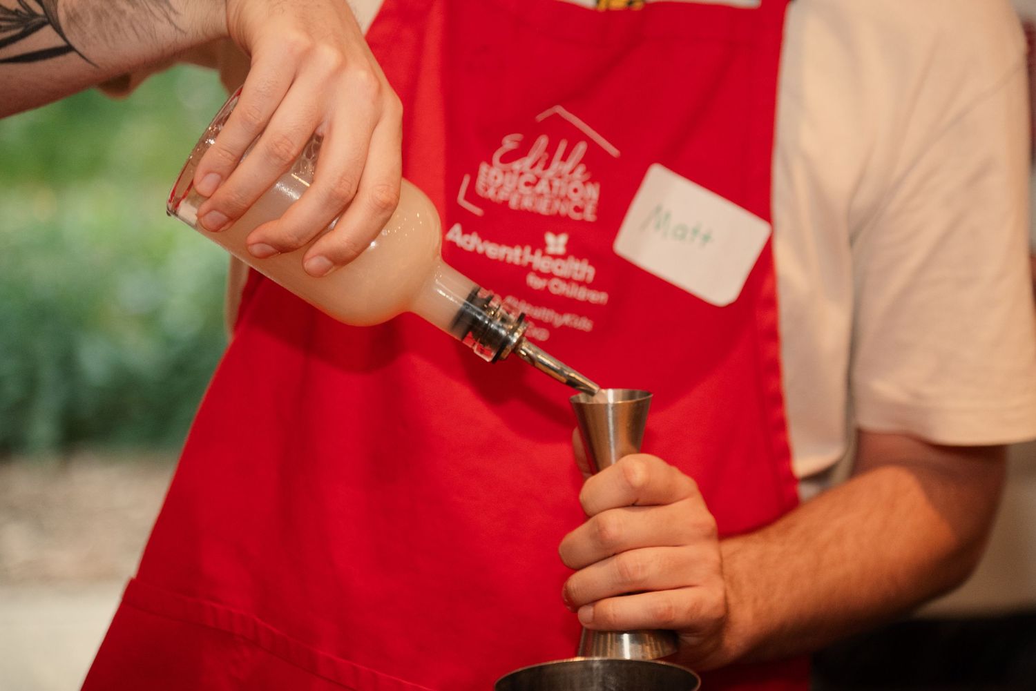 Students wearing red aprons working on food preparation during a cooking class.