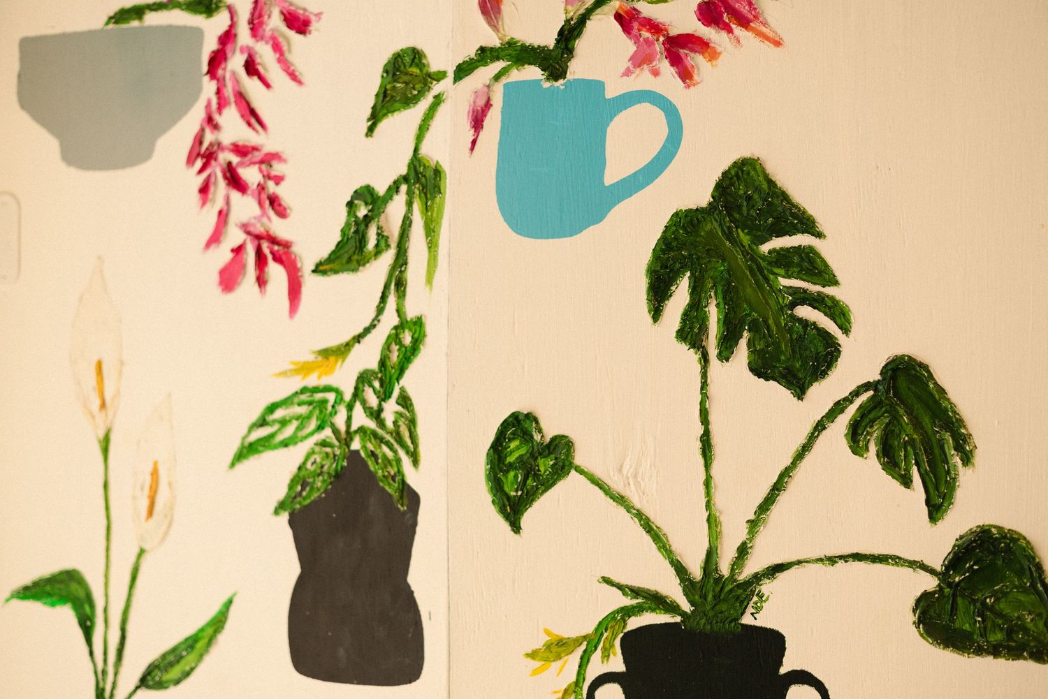 Botanical wall art with monstera leaves and pink flowers against cream background.