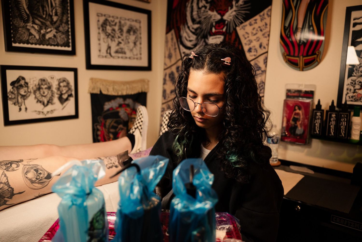 Artistic displays and blue decorative elements in a tattoo studio interior.