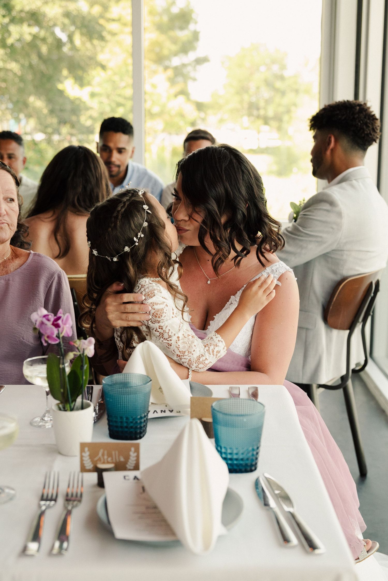 Intimate moment at an elegant reception dinner with blue glassware and floral centerpieces.