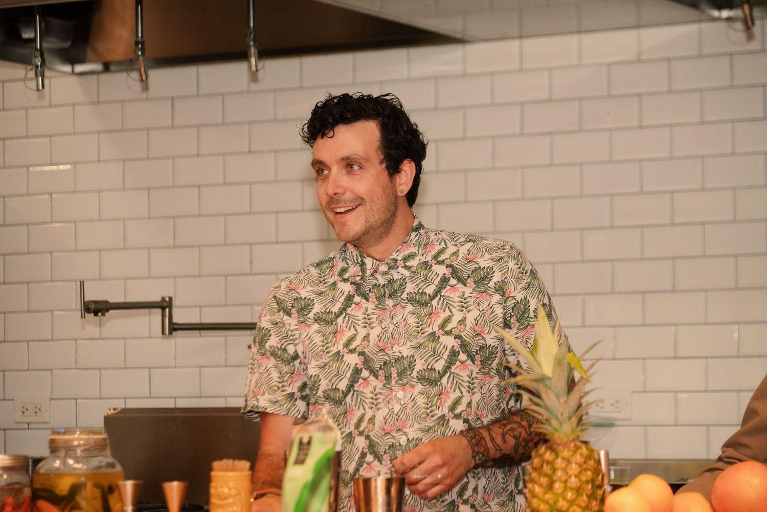Participants preparing tropical cocktails with pineapple and fresh ingredients.