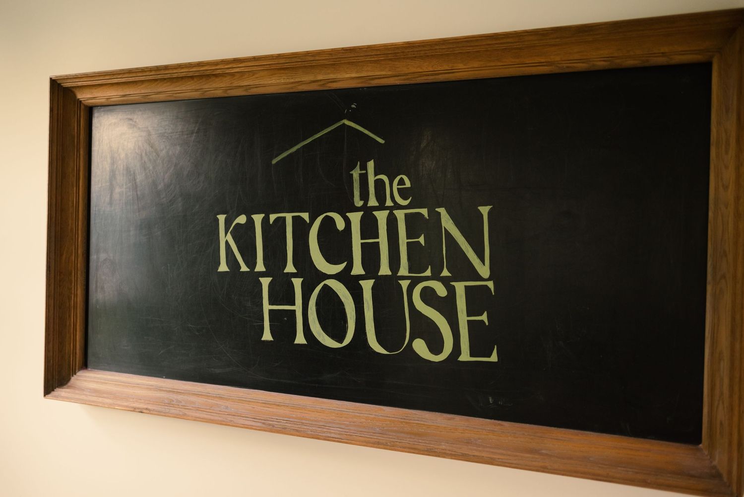 Wooden framed chalkboard signs displaying text for The Kitchen and House.