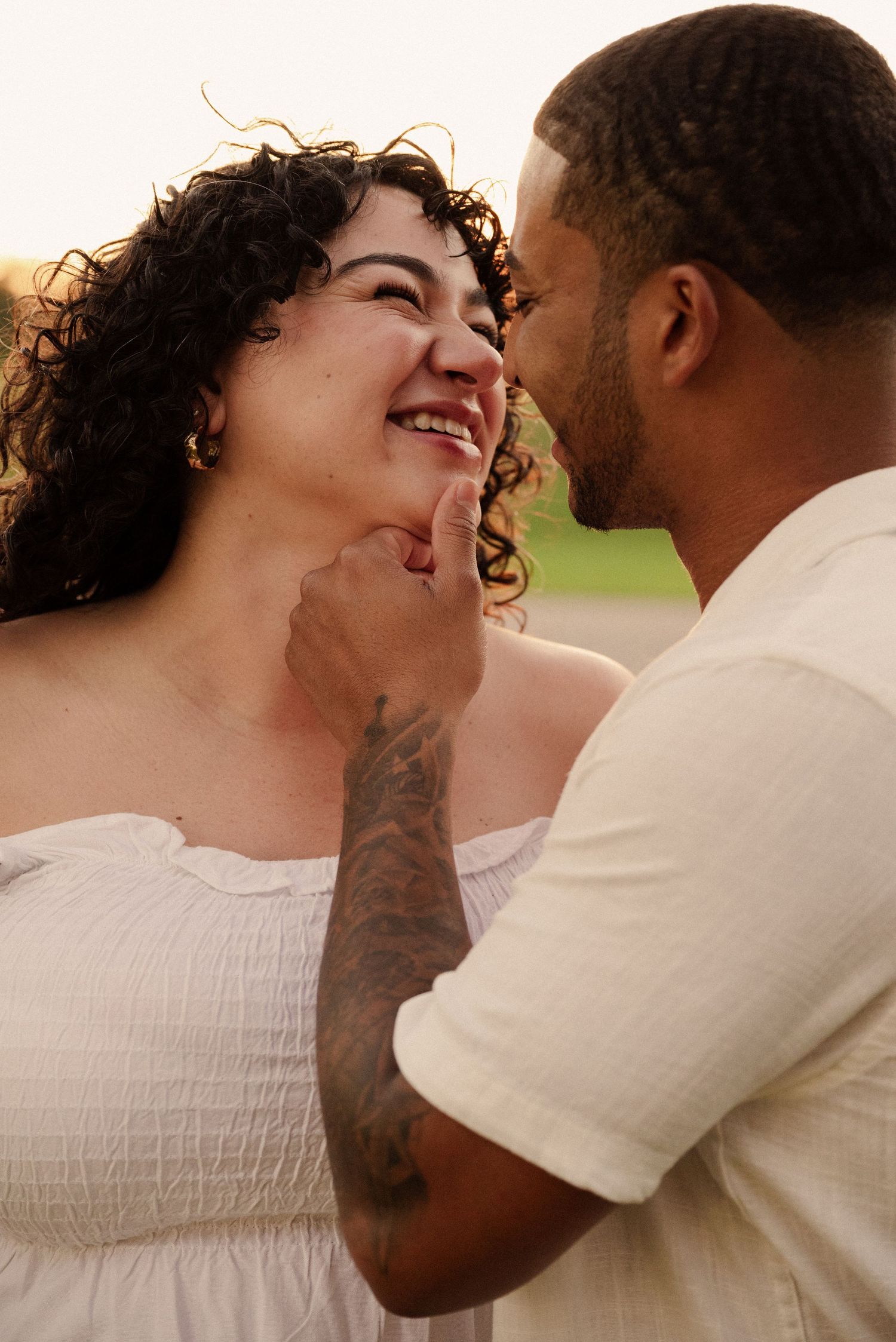 Close-up shots capture intimate moments between expectant couple at sunset.