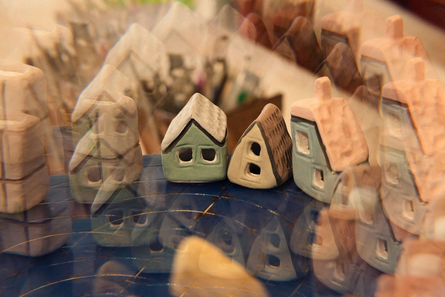 Collection of small ceramic houses arranged on a display surface.