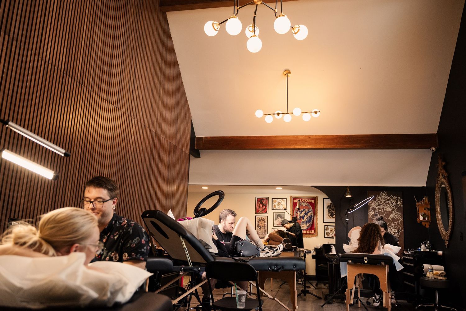 Interior of a tattoo studio with wood paneling and modern lighting fixtures.