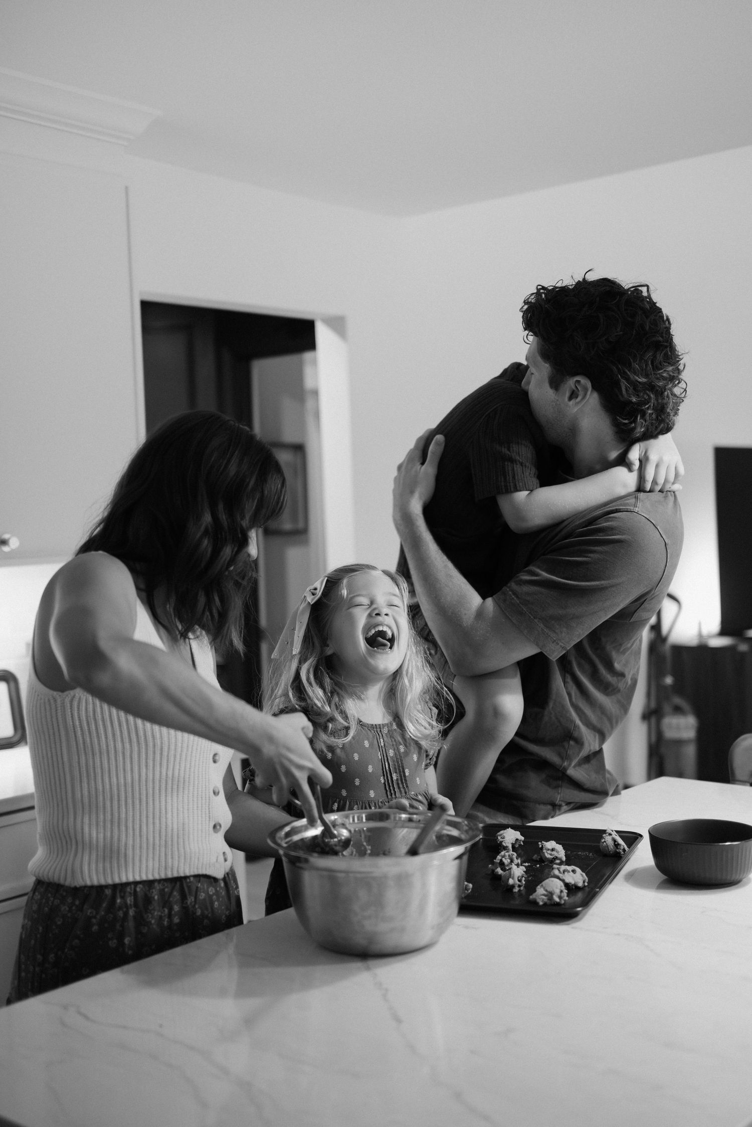A series of black and white photos capturing intimate moments between two people in a kitchen.