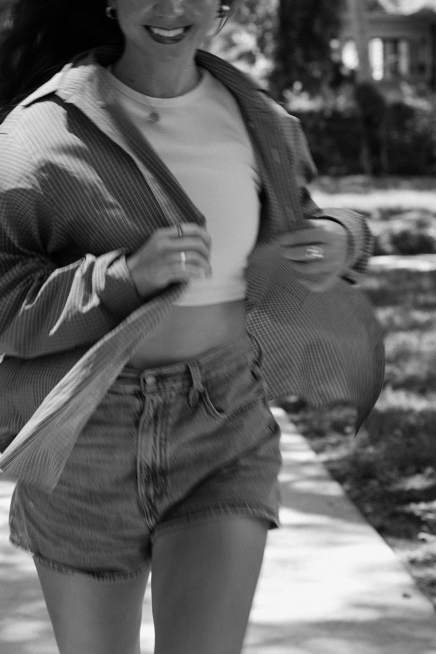 Black and white photo of someone wearing denim shorts and striped top.