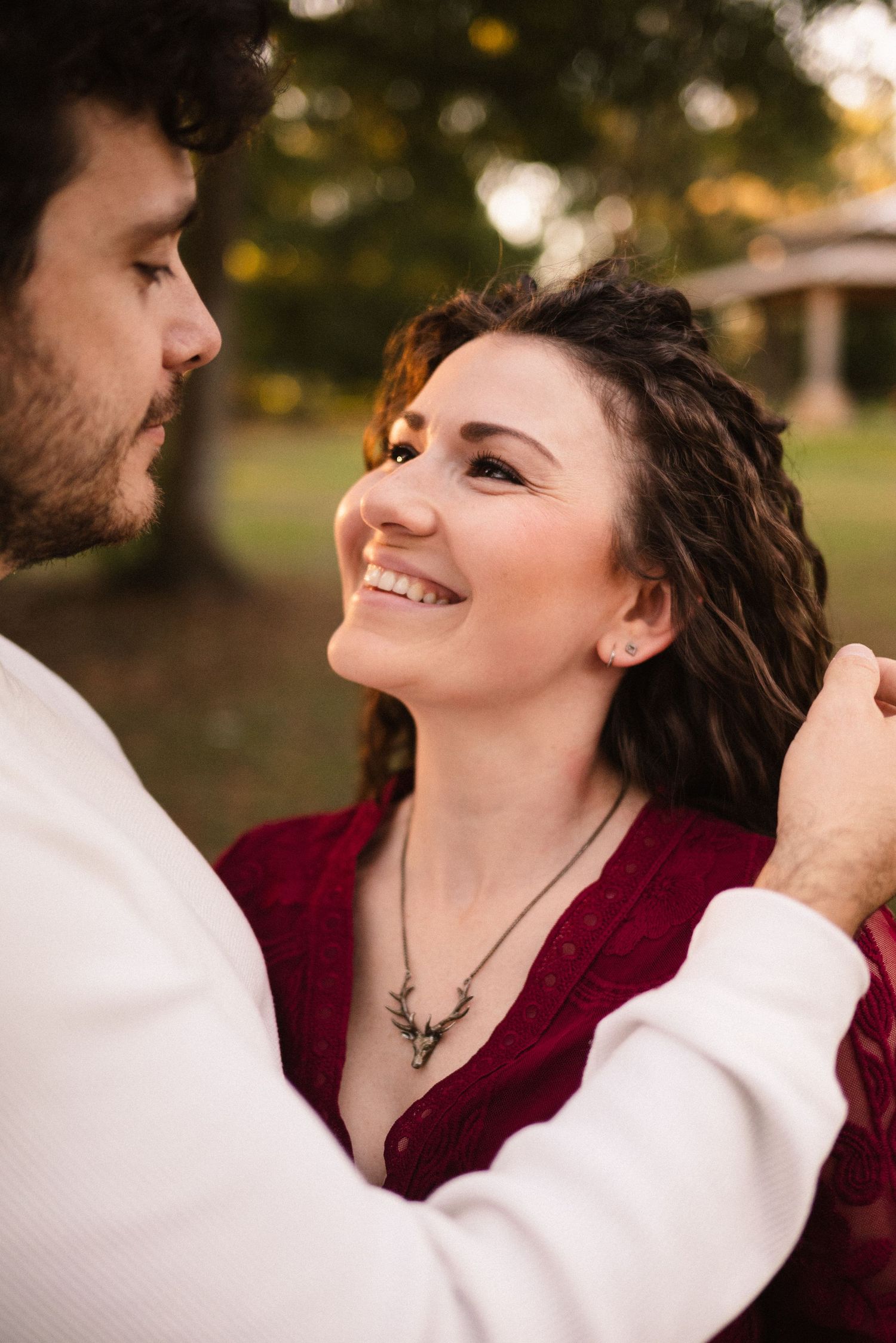 Close-up of couple sharing tender moment in outdoor setting with warm sunset lighting.