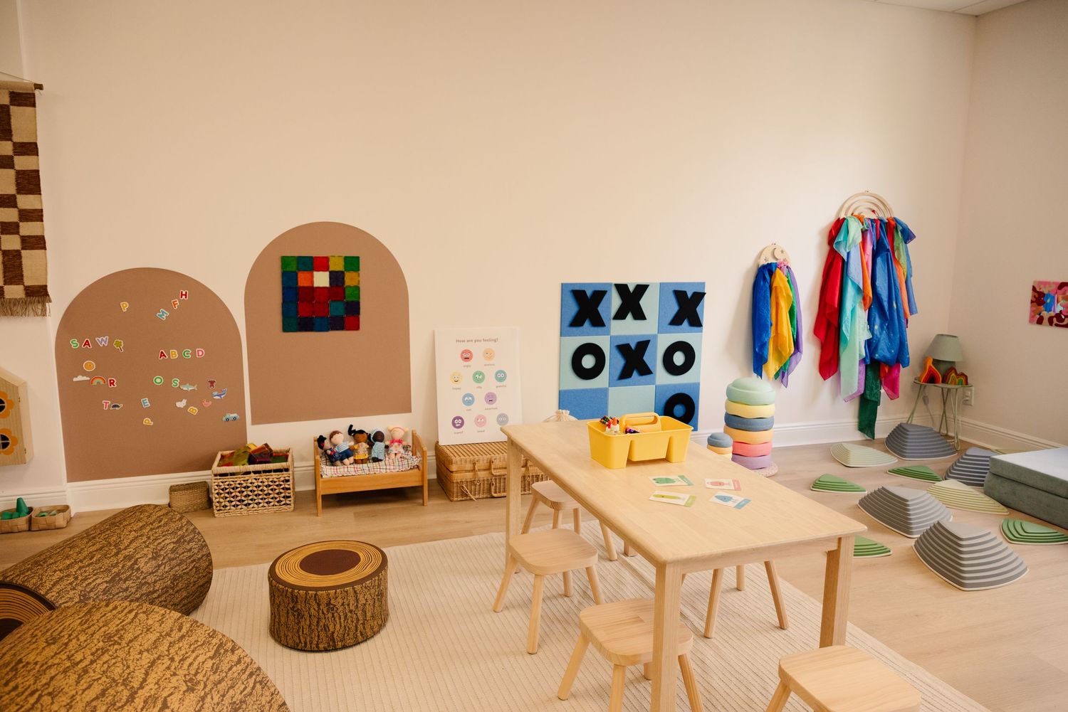 Modern playroom interior with natural wood elements and colorful wall decorations.