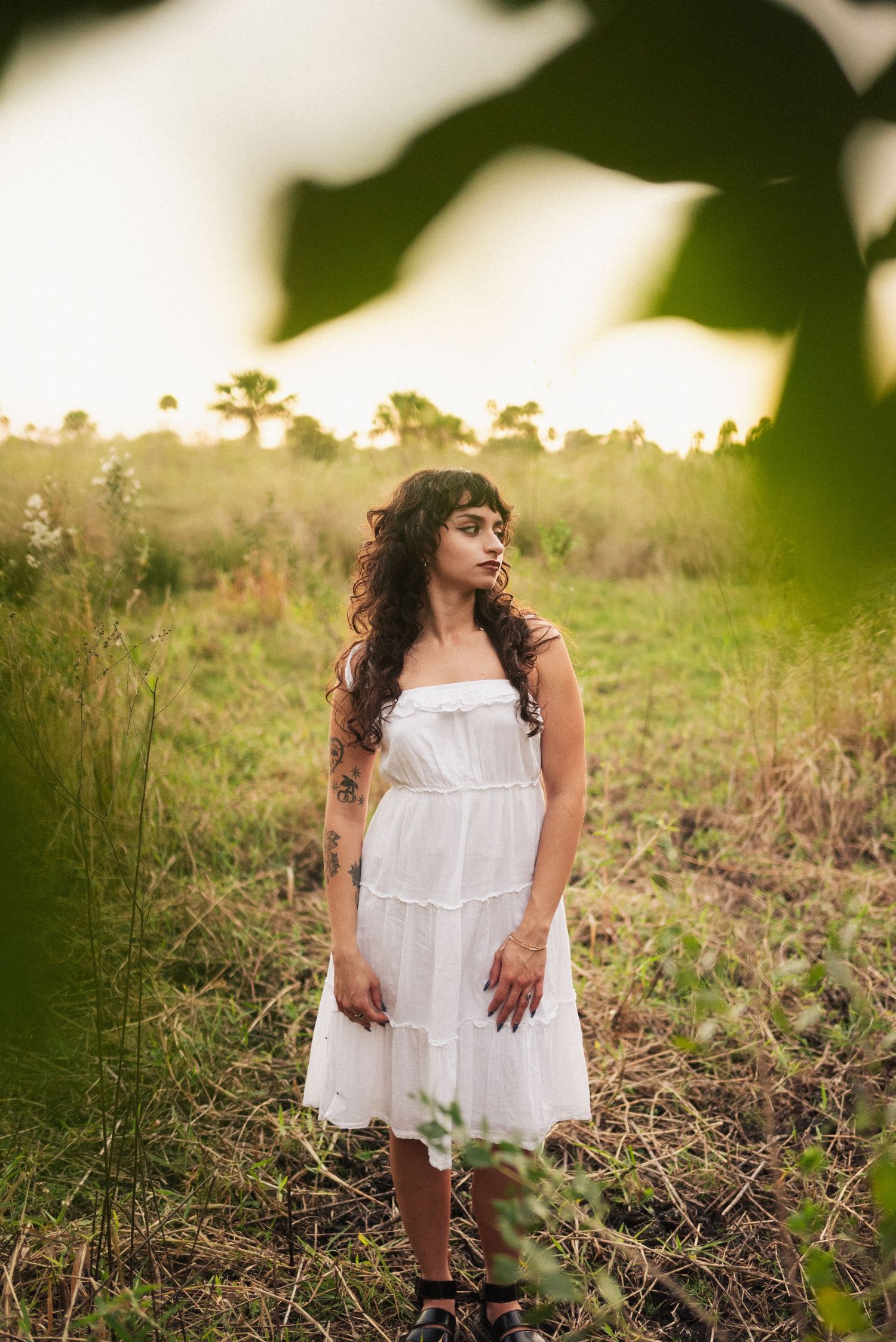 Portrait session in a white dress during golden hour in a field.