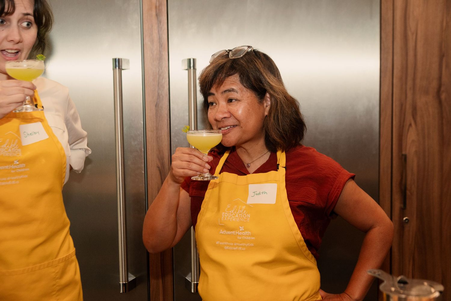 Group wearing yellow aprons participating in a cocktail making workshop.
