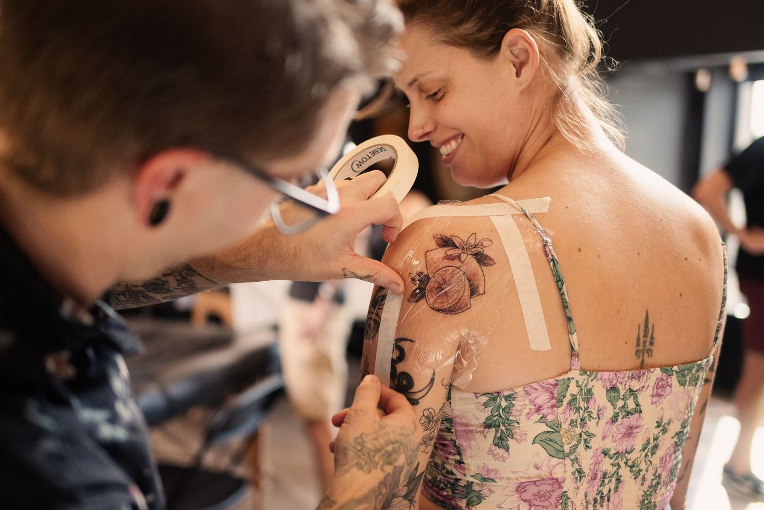 Behind-the-scenes footage shows a tattoo artist at work in an elegant studio with ornate branding.