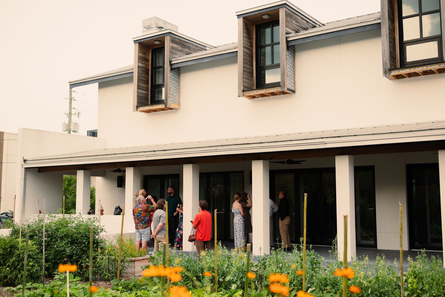 Modern building exterior with white columns and landscaping visible in daylight.