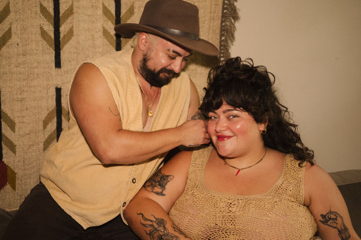 A romantic outdoor photoshoot featuring a couple in vintage-inspired attire sharing intimate moments.