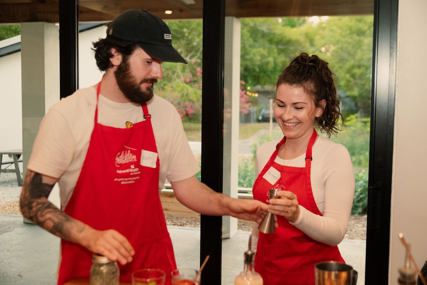 Cooking class participants in red aprons learning kitchen skills together.