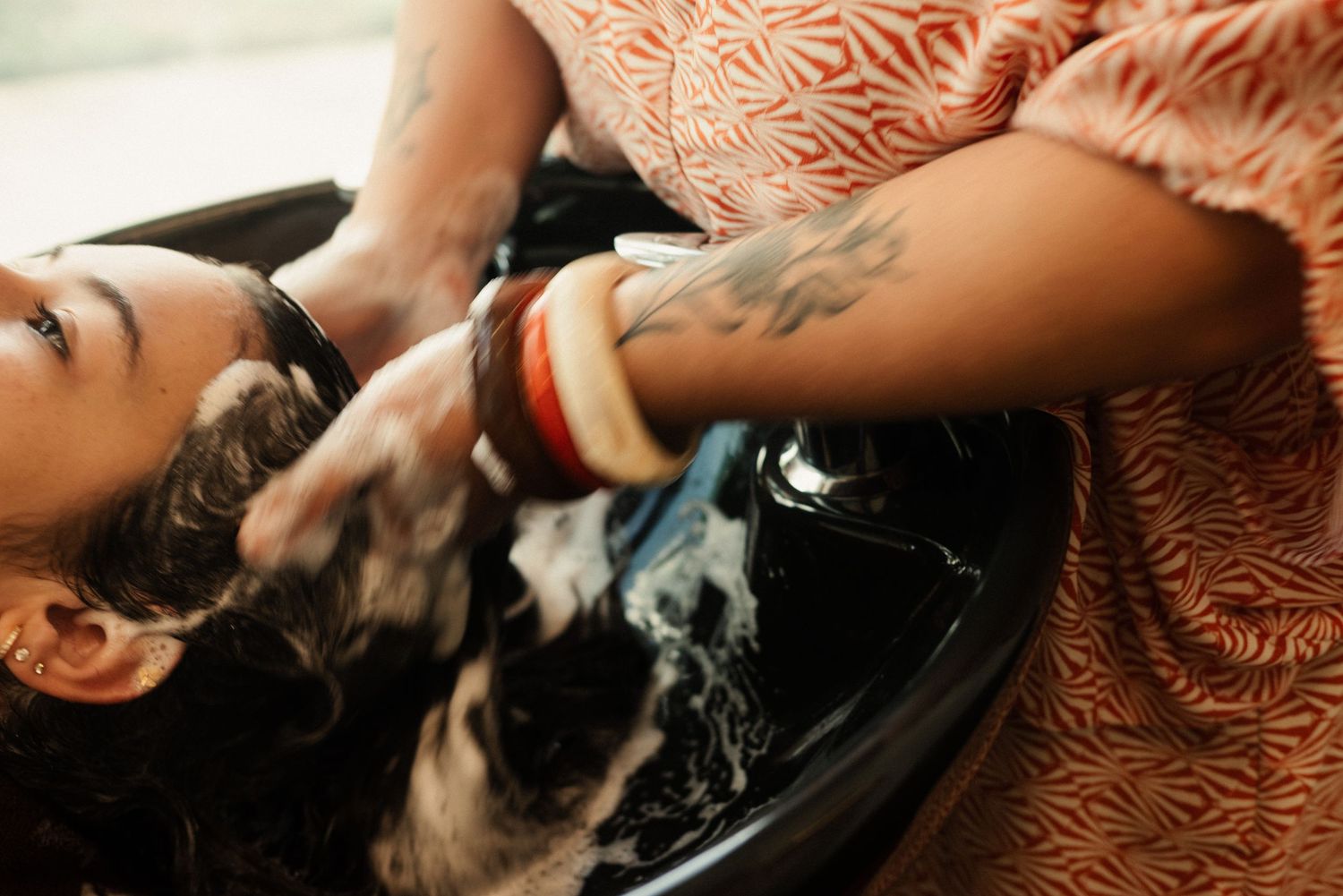 Hair washing service being performed in a professional salon setting.